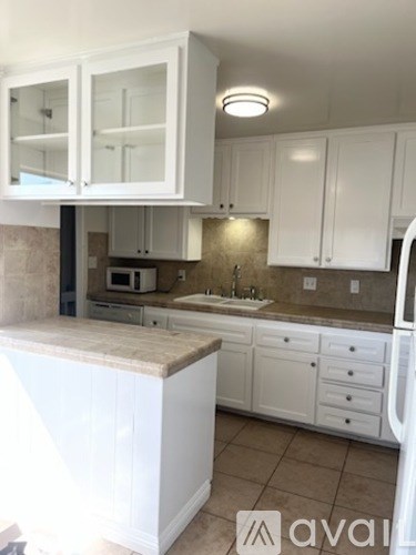 A kitchen with white cabinets and a countertop.