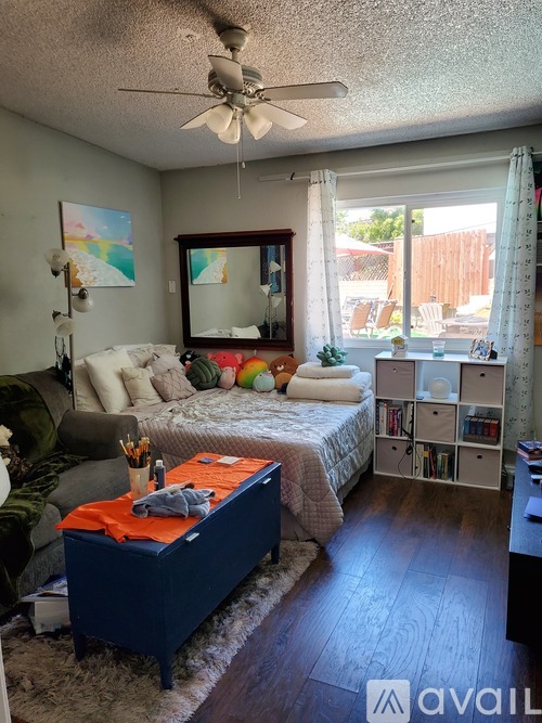 A bedroom with a bed, a chair, a dresser, and a mirror.