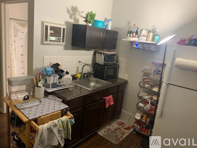 A kitchen with a sink, a refrigerator, and a microwave.