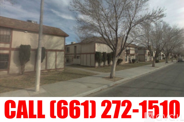 A residential street with houses on both sides and a utility pole in the foreground.