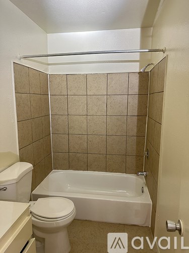 A bathroom with a toilet, tub, and towel bar.