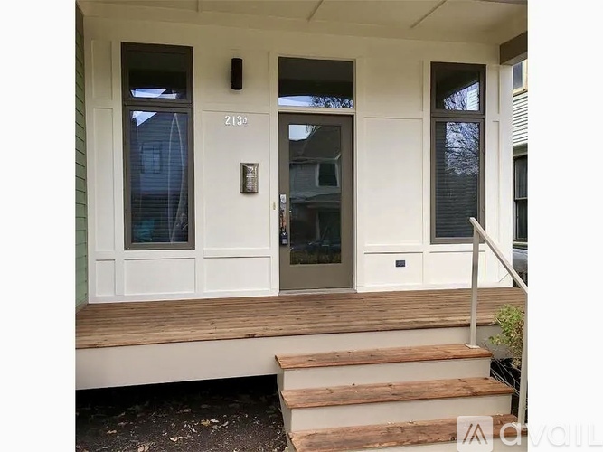 The front door of a house with a glass window and a white frame.