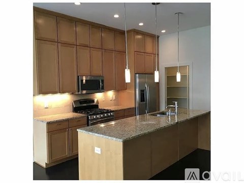 A kitchen with brown cabinets and a granite countertop.