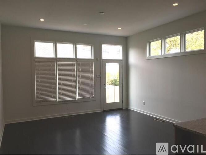 A spacious room with a sliding glass door and a window with blinds.
