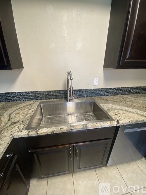 A kitchen with black cabinets and a white refrigerator.