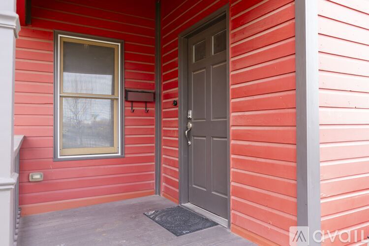 A red house with a brown door and a window.