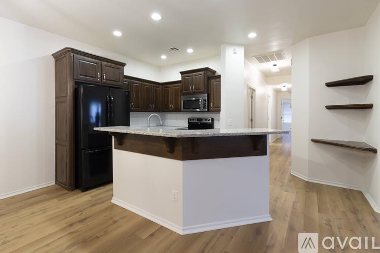 A modern kitchen with dark brown cabinets and a white island.