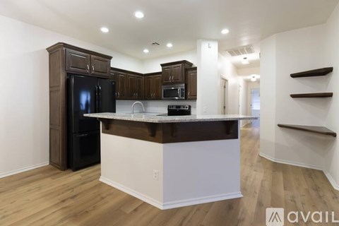 A modern kitchen with dark brown cabinets and a white island.