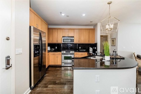 A kitchen with wooden cabinets and a black countertop.