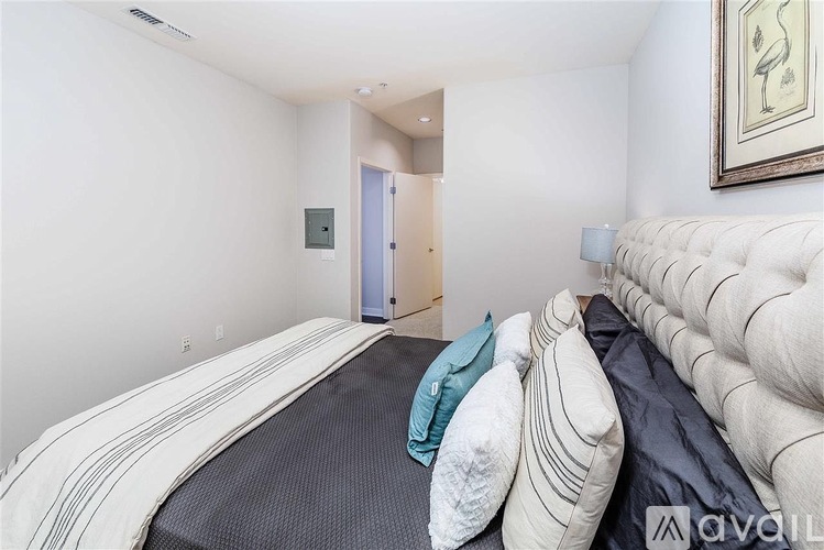 A bedroom with a large bed and a painting on the wall.