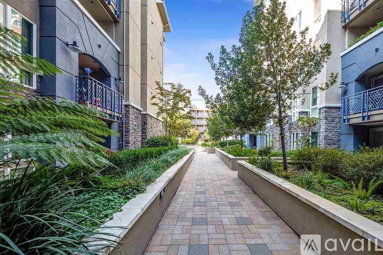 A long brick pathway leads between two rows of apartment buildings.