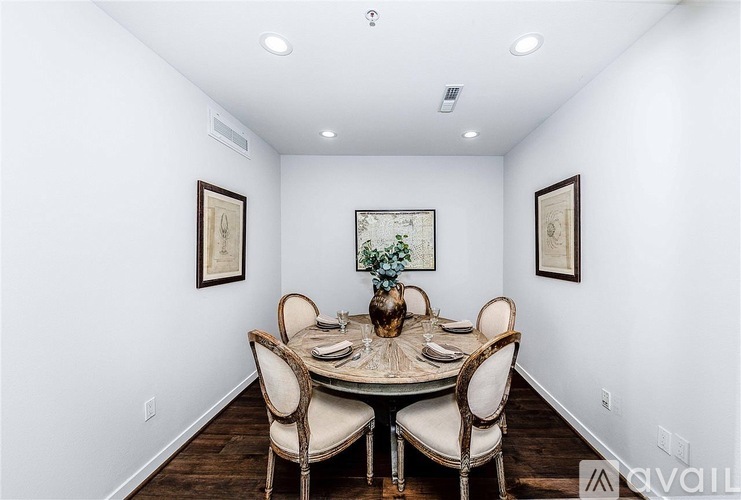 A dining room with a round table surrounded by chairs.