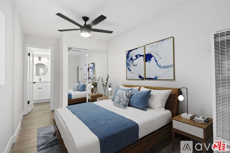 A bedroom with a bed, nightstand, and a ceiling fan.