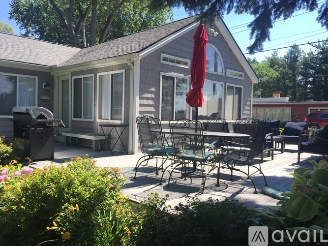 A patio with chairs and a table is set up outside a house.