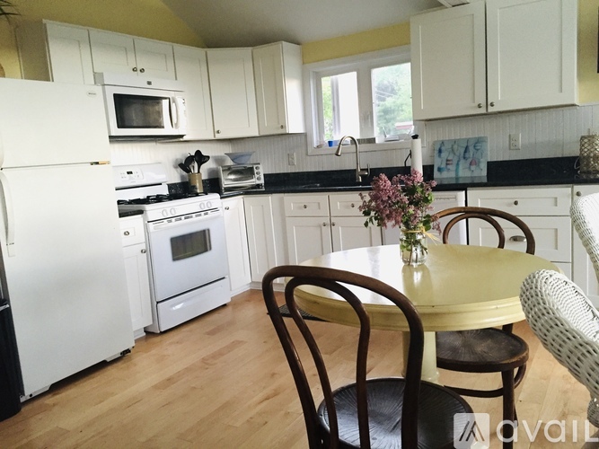A kitchen with a table and chairs.