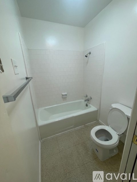 A white bathroom with a toilet, tub, and shower.