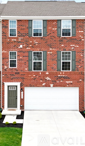 A red brick house with a white garage door.