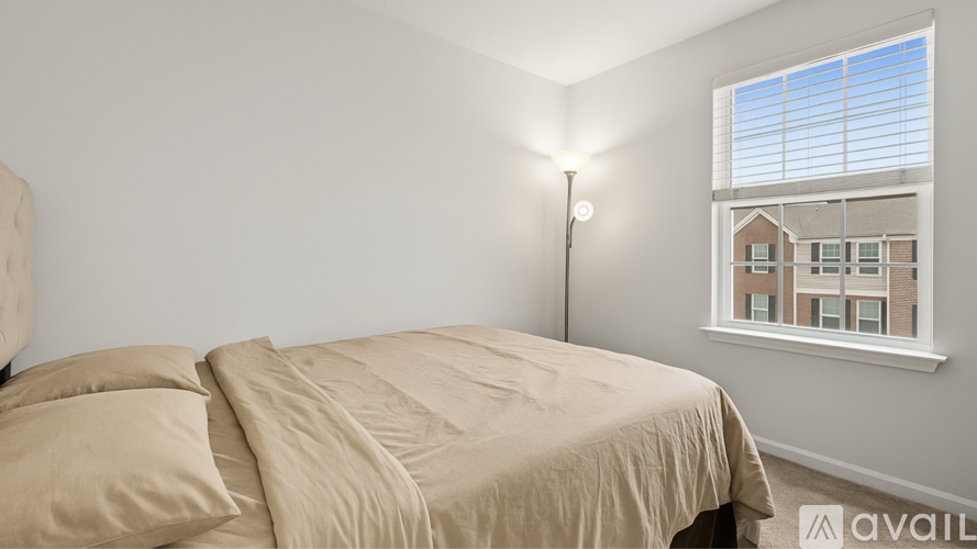 A bedroom with a large bed and a window overlooking a building.