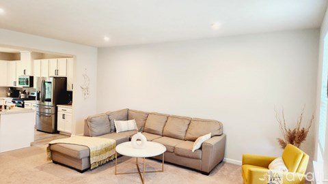 A living room with a grey couch and a yellow chair.