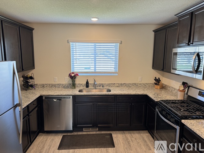 A kitchen with black cabinets and stainless steel appliances.
