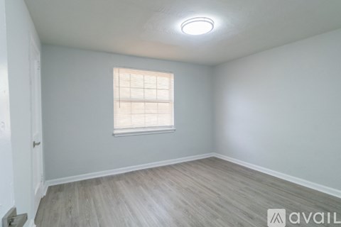 A room with a window and wooden flooring.
