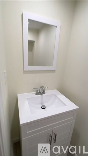 A white sink in a cabinet with a mirror above it.