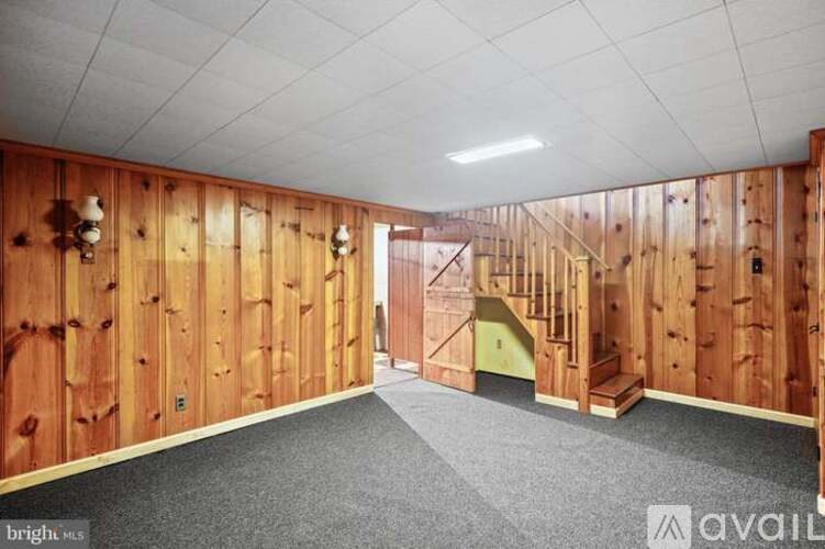 A room under construction with wooden walls and a staircase.