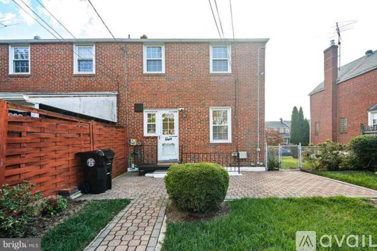 A brick house with a white door and a small garden in front.