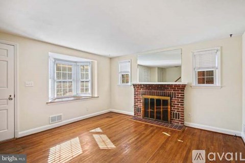 A room with a fireplace and wooden floors.