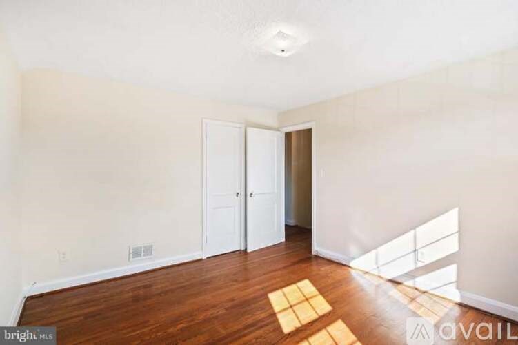 A room with a wooden floor and a white door.