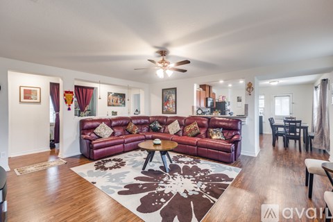 A living room with a red couch and a rug.