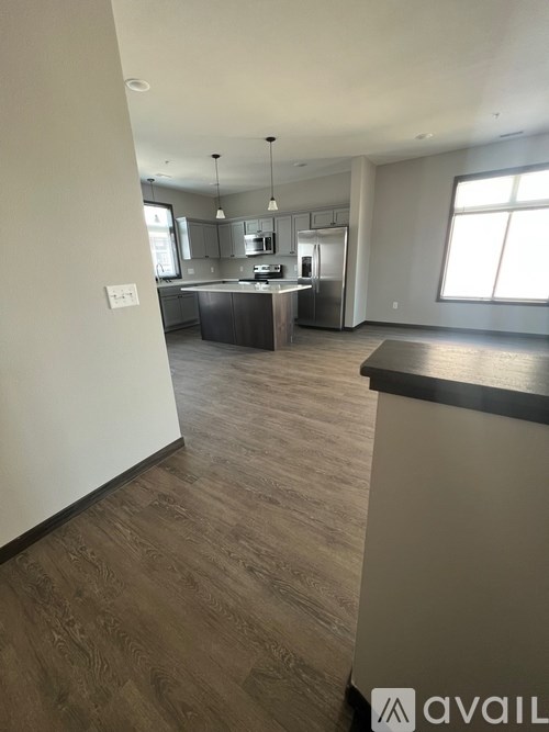 A modern kitchen with wooden floors and a large island.