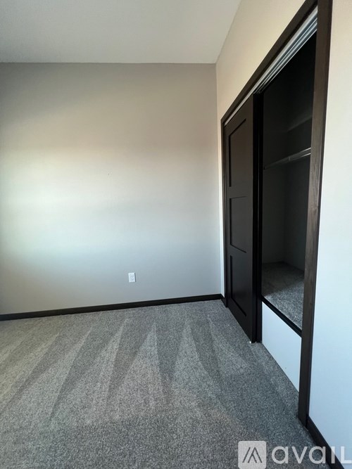 A carpeted room with a door on the right.