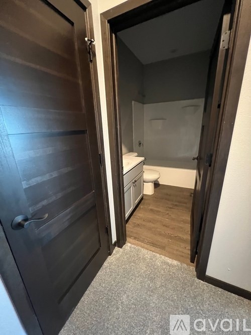 A bathroom with a toilet and sink is visible through a door.