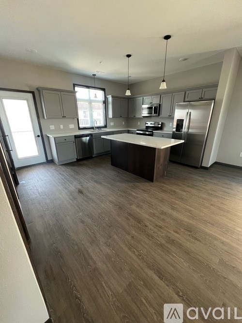 A kitchen with a wooden floor and a large island in the middle.