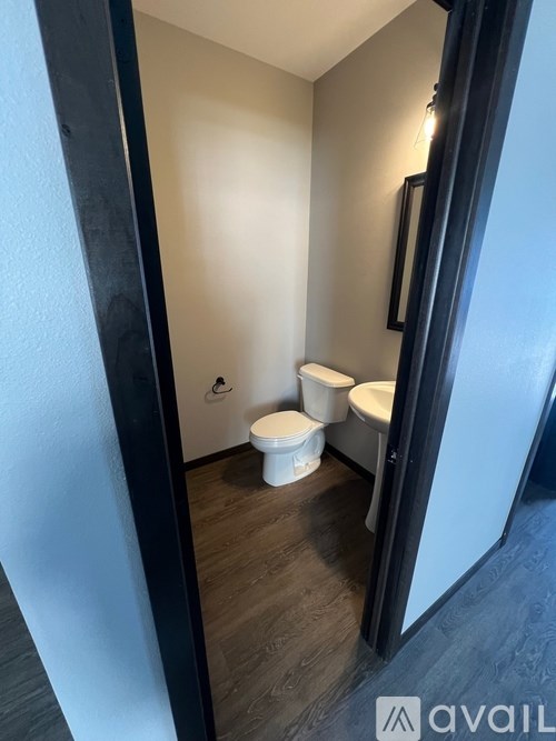 A bathroom with a toilet and a toilet paper roll on the floor.