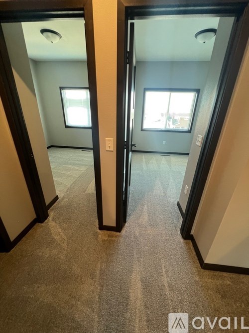 A hallway with a carpeted floor and a door on the right.