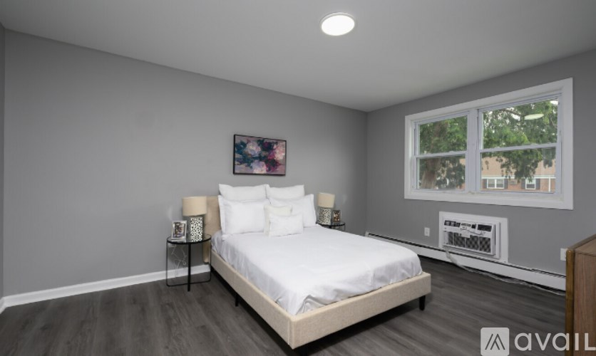 A bedroom with a bed, nightstands, and a window.