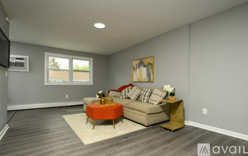 A living room with a couch, a coffee table, and a painting on the wall.