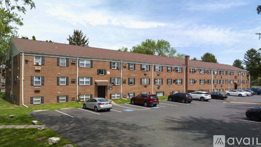 A parking lot in front of a brick apartment building.