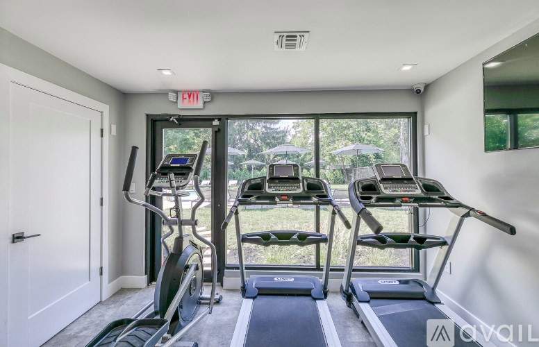 A gym with treadmills and an exit sign.