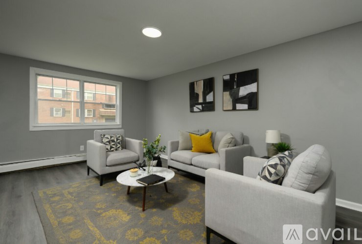 A living room with a grey couch, a coffee table, and a large window.