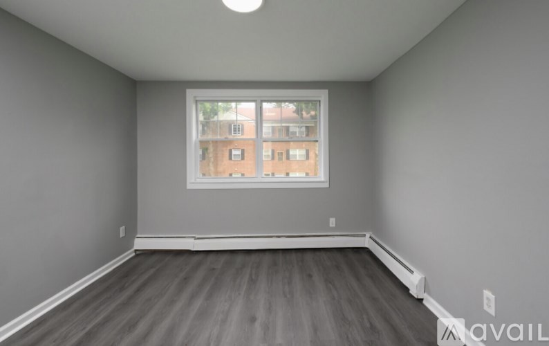 A room with a window and a wooden floor.