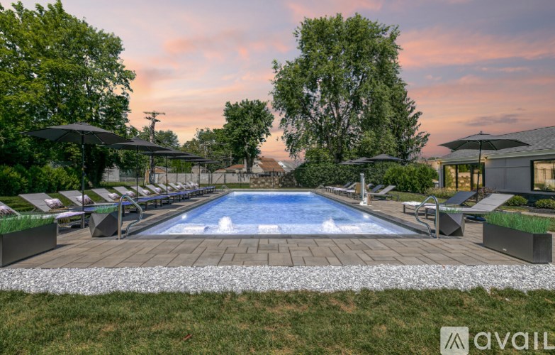 A large outdoor swimming pool surrounded by lounge chairs and umbrellas.