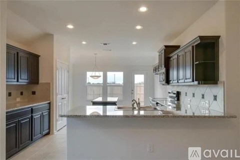 A modern kitchen with dark wood cabinets and a white island.