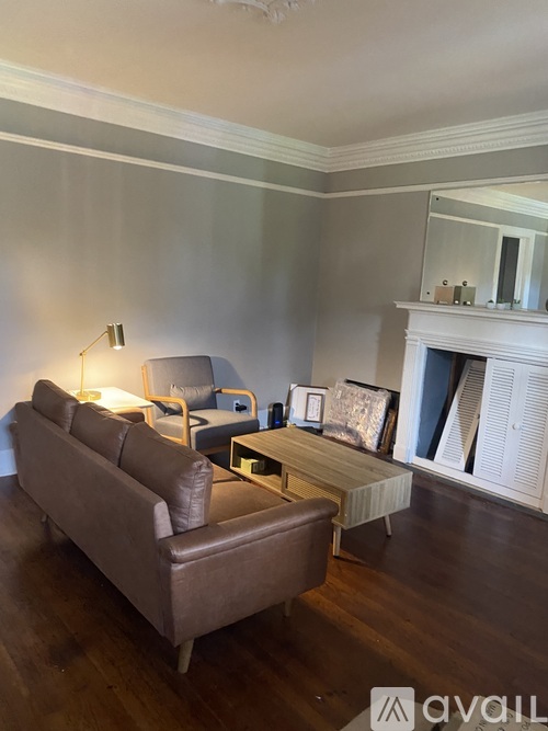 A living room with a brown couch and a coffee table.