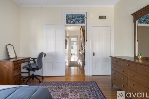 A bedroom with a large bed and a desk.