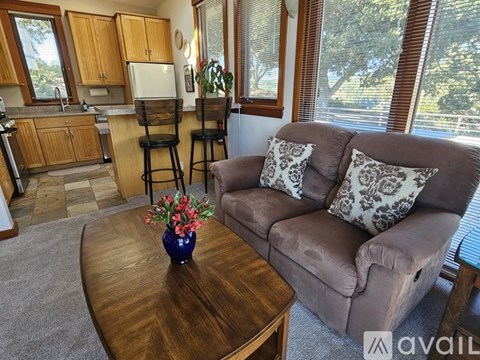 A living room with a brown couch and a wooden coffee table.