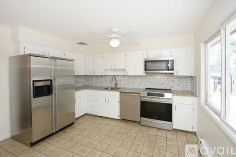 A kitchen with a stainless steel refrigerator and microwave.