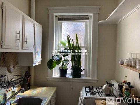 A kitchen with a window, sink, and stove.